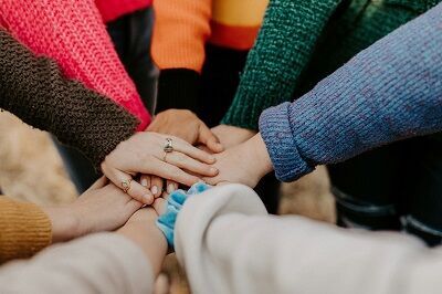 eine Gruppe von Menschen, die in einem Kreis Hände halten