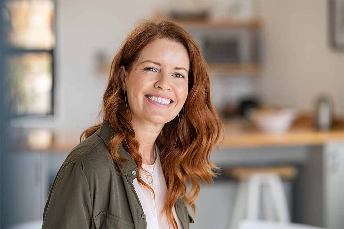 eine Frau mit rotem Haar und einer grünen Jacke