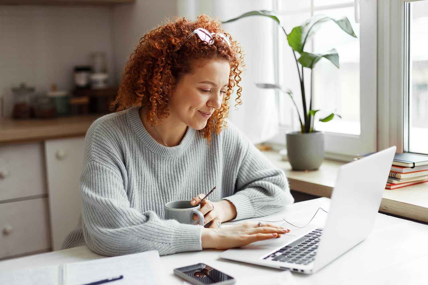 eine Frau, die an einem Schreibtisch mit Laptop und Kalkül sitzt